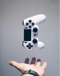 A male hand trowing a PS4 controller into the air.